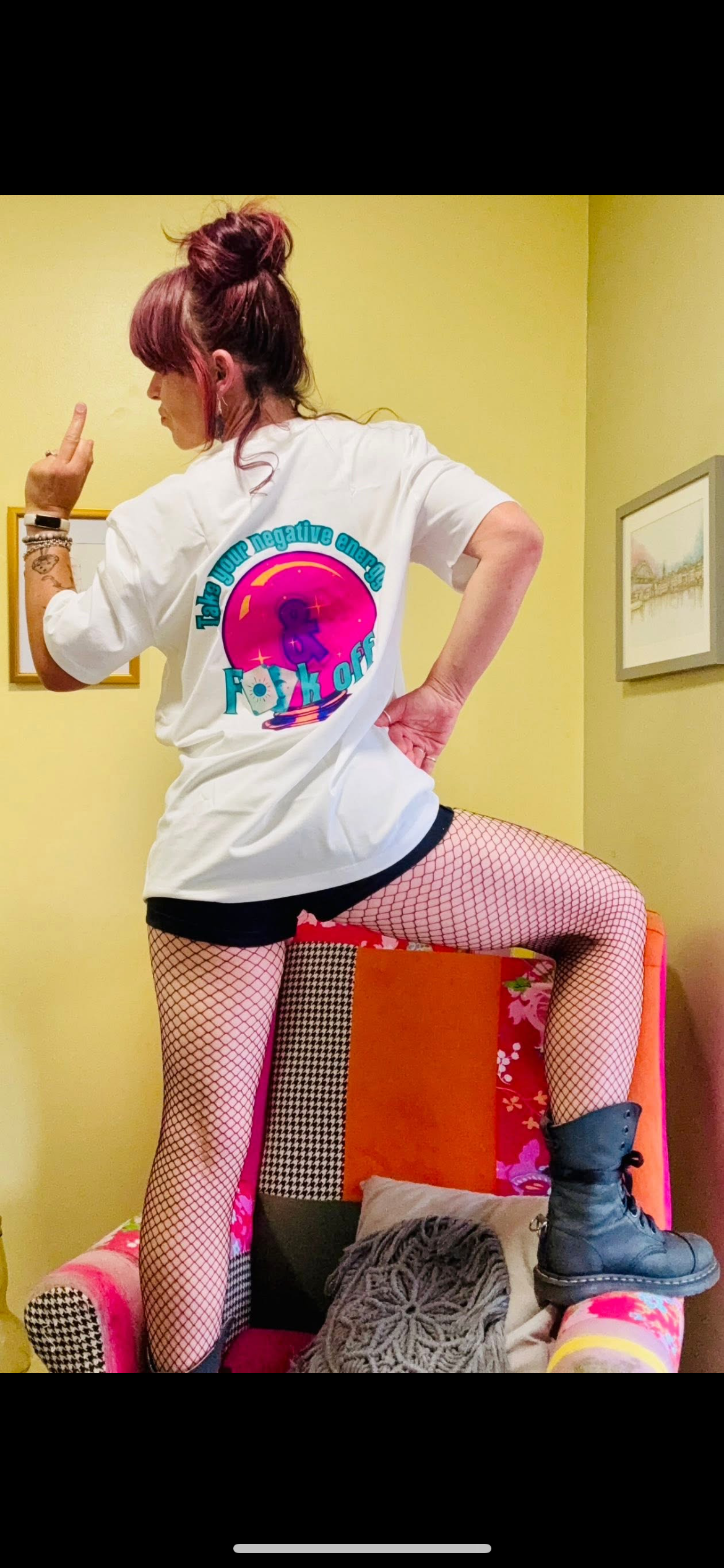 Kylie Dixon MBE wearing a Something Profound T-shirt with ‘take your negative energy and fuck off sticking her middle finger up