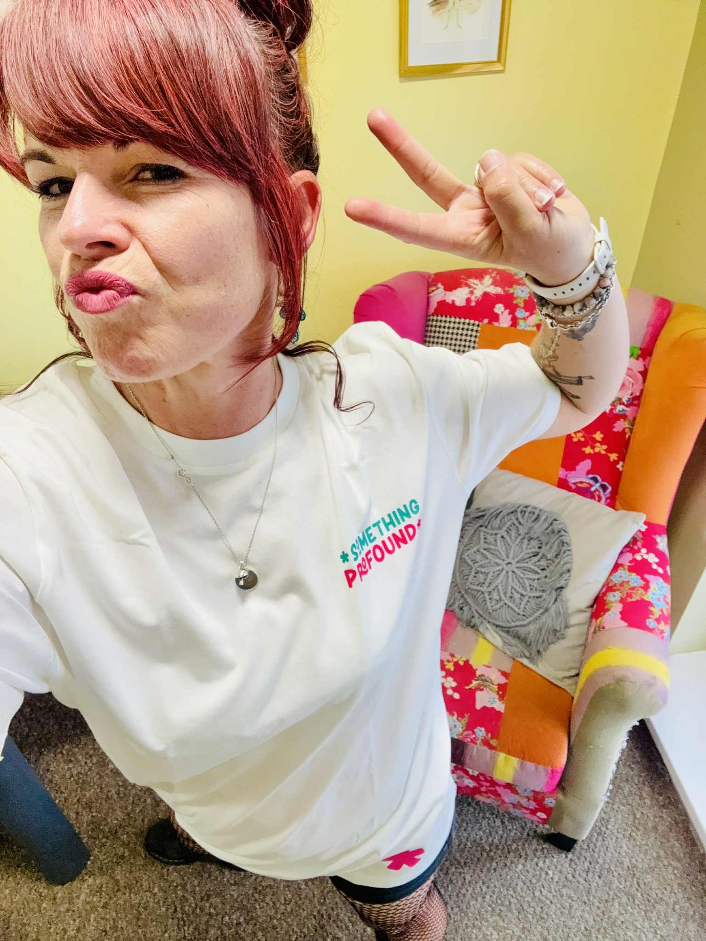 Kylie Dixon MBE wearing a Something Profound T-shirt and pouting making a peace sign