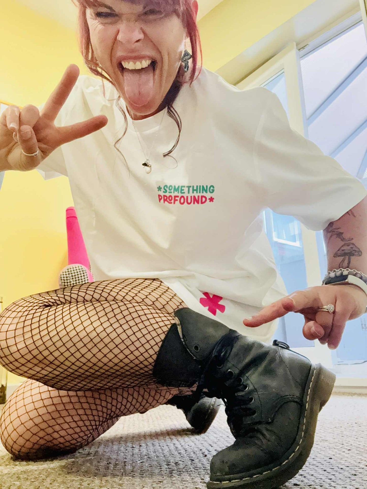 Kylie Dixon MBE wearing a Something Profound T-shirt showing off the asterisk making peace sign