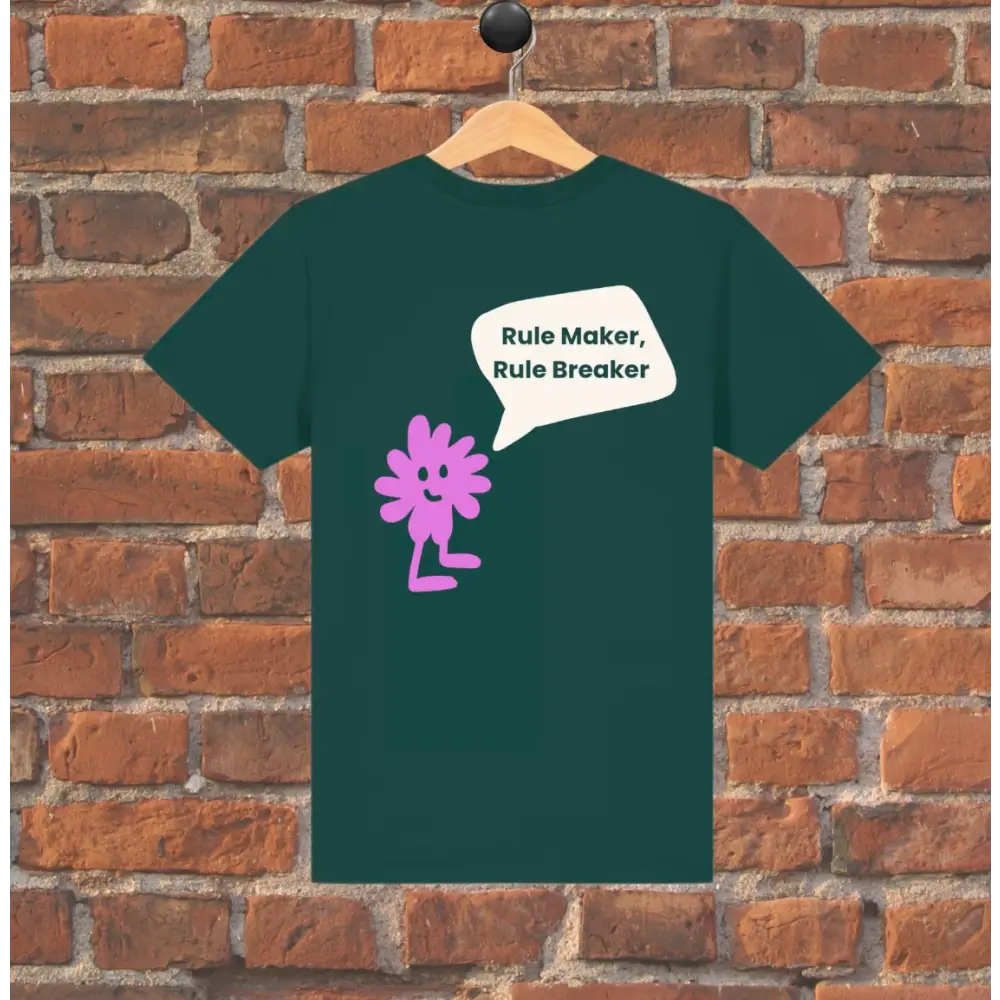 Green t-shirt with a purple flower and text on a wooden hanger against a brick wall.