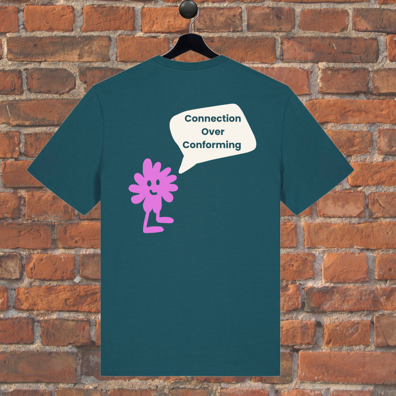 Green t-shirt with pink character and speech bubble on a brick wall background