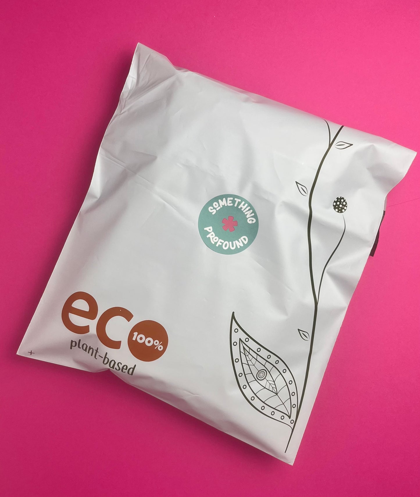 A white biodegradable mailer bag with 'eco 100% plant-based' branding and a green 'Something profound' logo, photographed on a solid pink background.