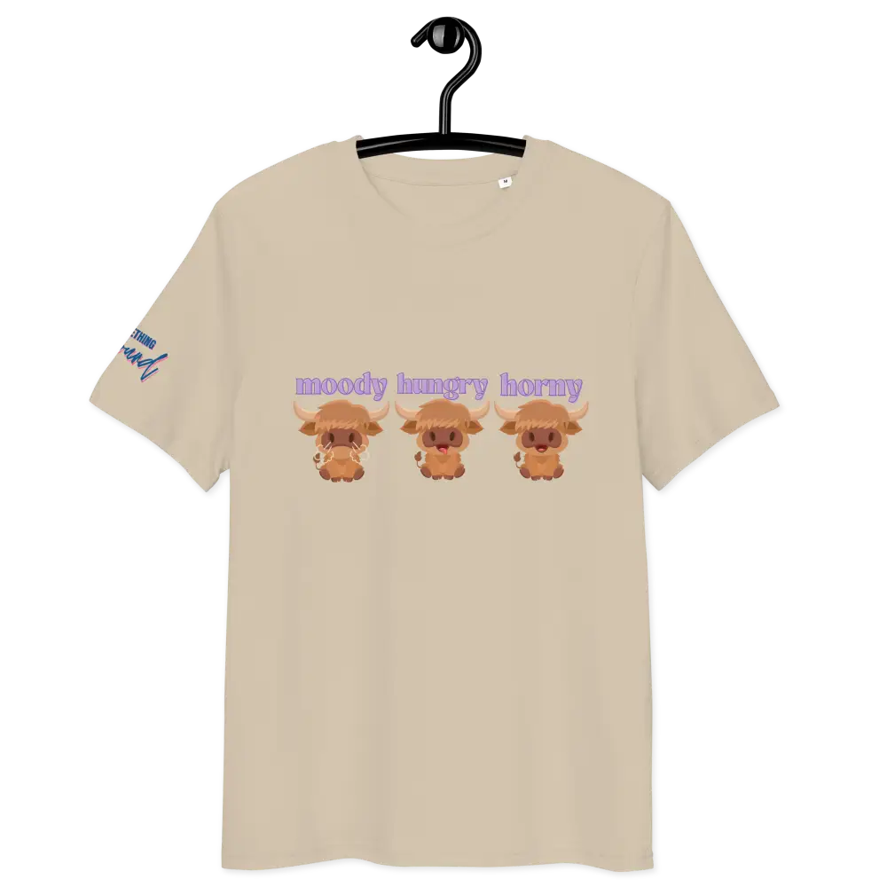 Beige t-shirt with cartoon highland cows and text on a hanger against a white background