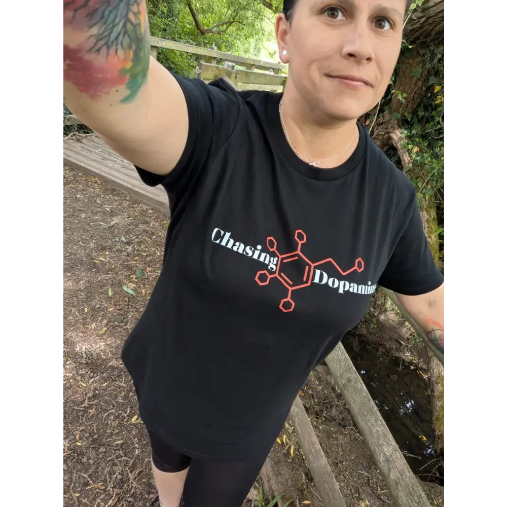 Person wearing a black t-shirt with 'Chasing Dopamine' design outdoors.