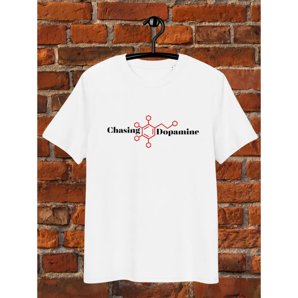 White t-shirt with 'Chasing Dopamine' design on a hanger against a brick wall.