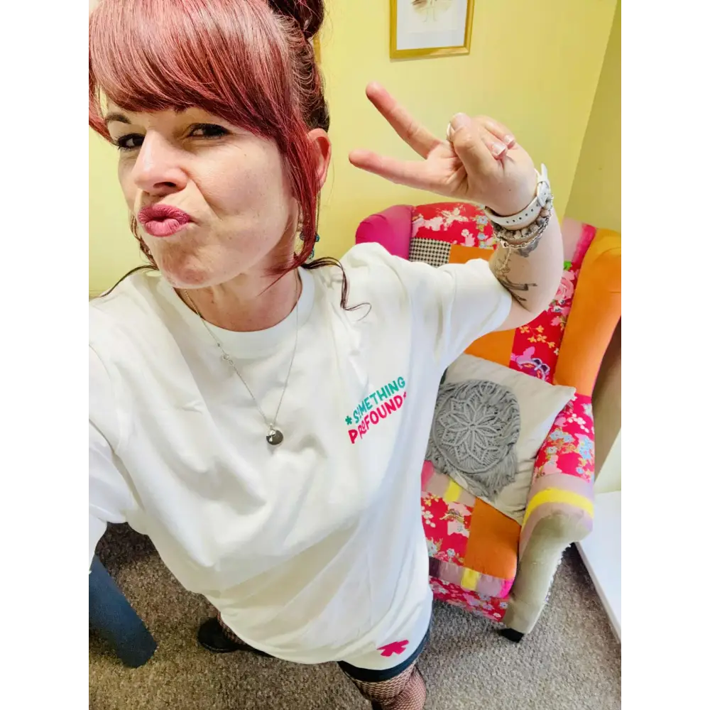 Kylie Dixon MBE wearing a Something Profound T-shirt and pouting making a peace sign