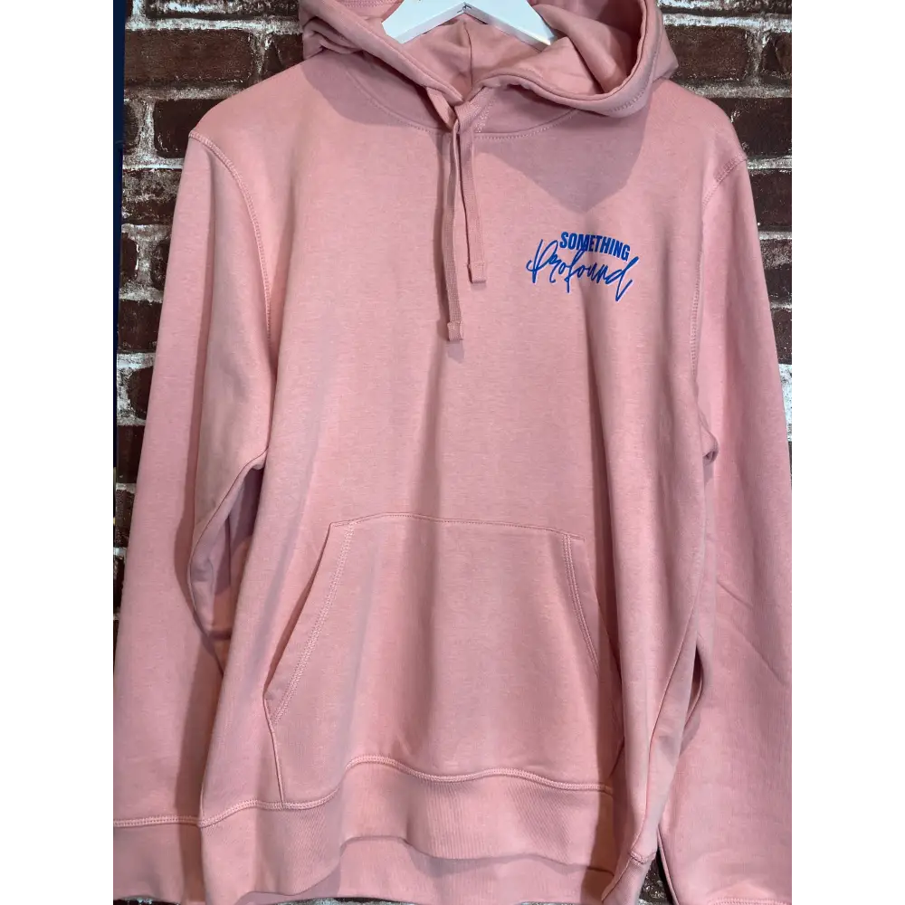 Pink hoodie with blue text on a brick surface
