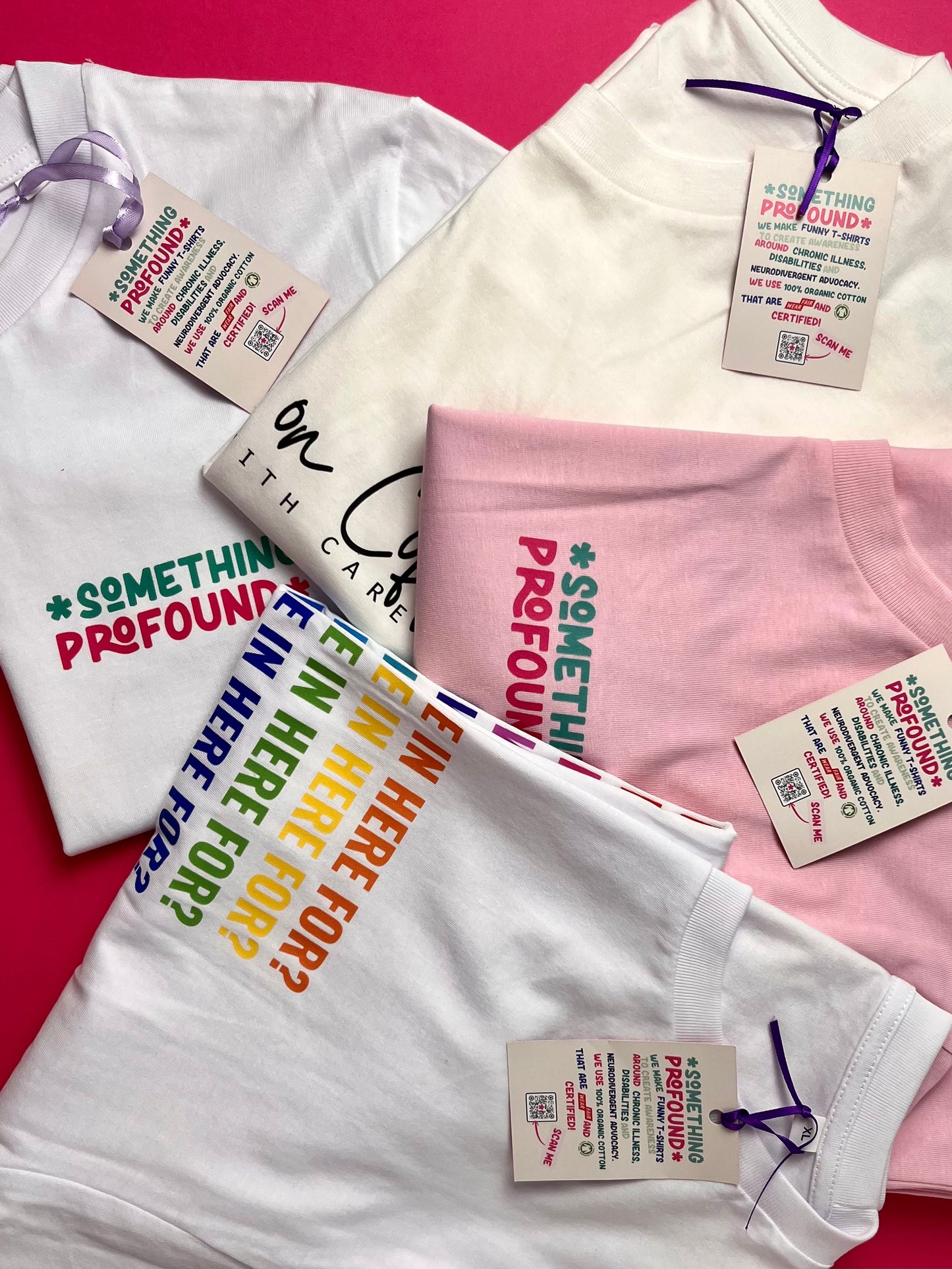 White t-shirt with colorful text and pink t-shirt with text on a pink background