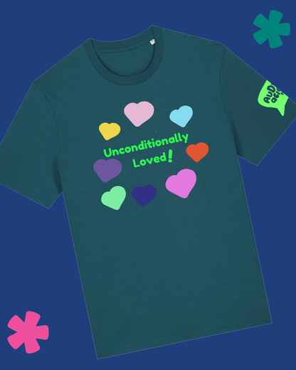 A dark teal t-shirt with a graphic of colorful hearts and the text 'Unconditionally Loved!' on the front, shown against a dark blue background with decorative pink and green flower shapes.