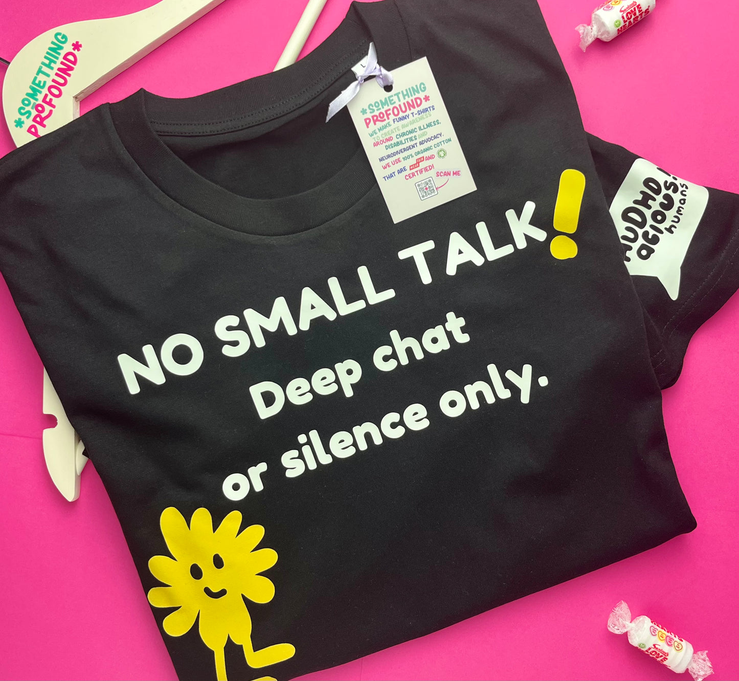 A folded black graphic T-shirt on a bright pink background. The shirt has white text reading 'NO SMALL TALK! Deep chat or silence only.