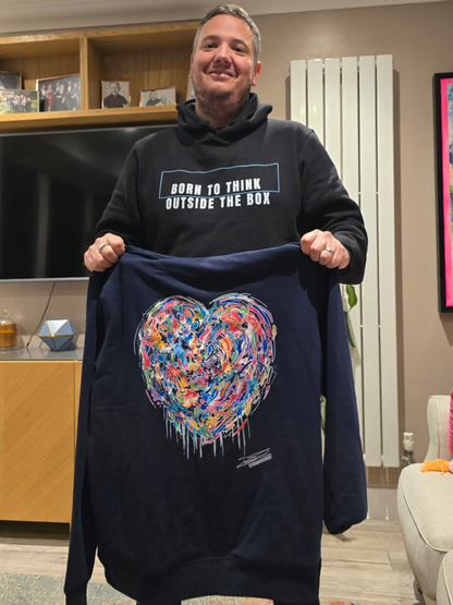 David Kirkman wearing born to think outside the box and holding graffiti heart hoodie 
