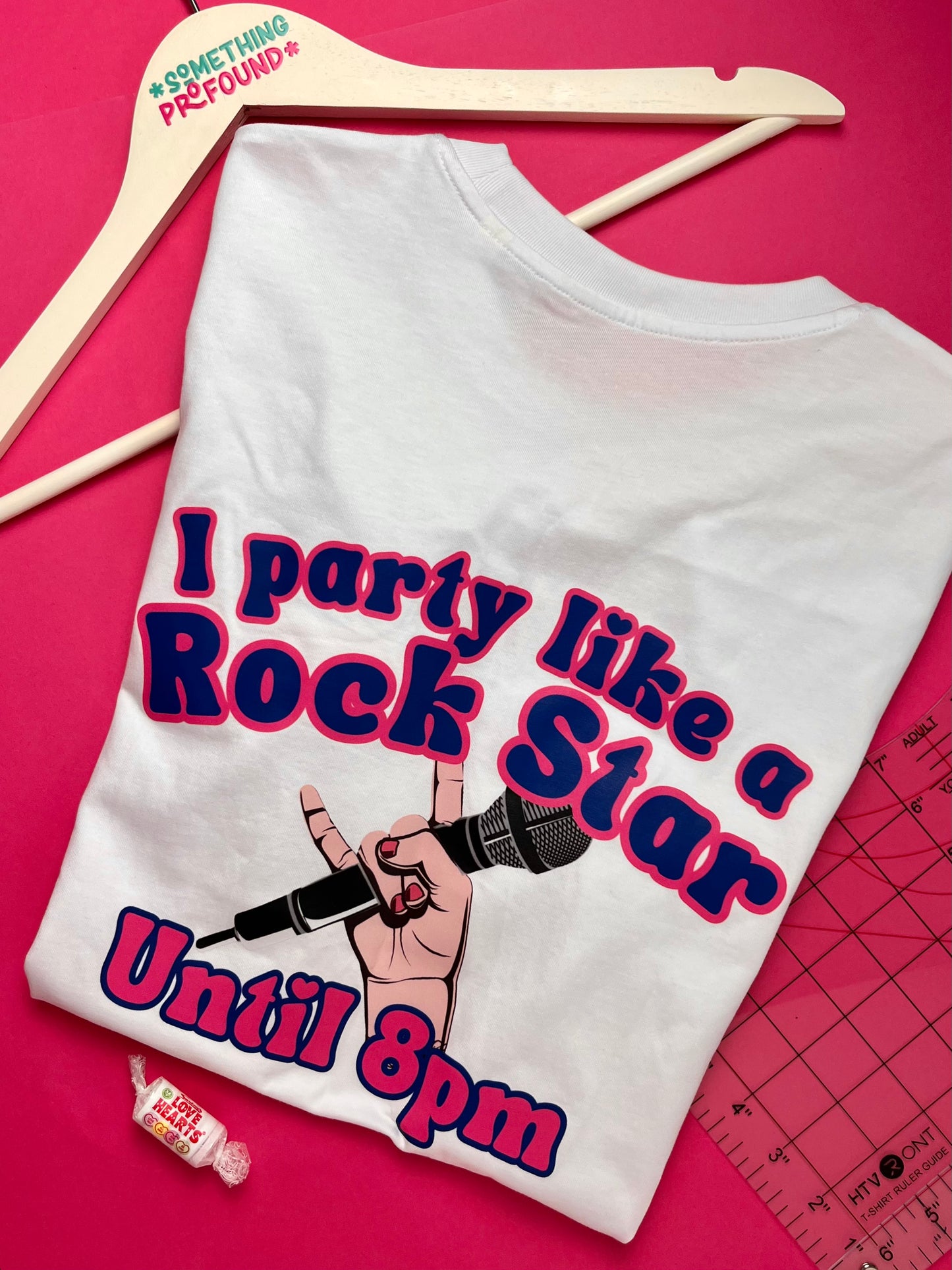 White t-shirt with 'I party like a rock star until 8pm' design on a pink background