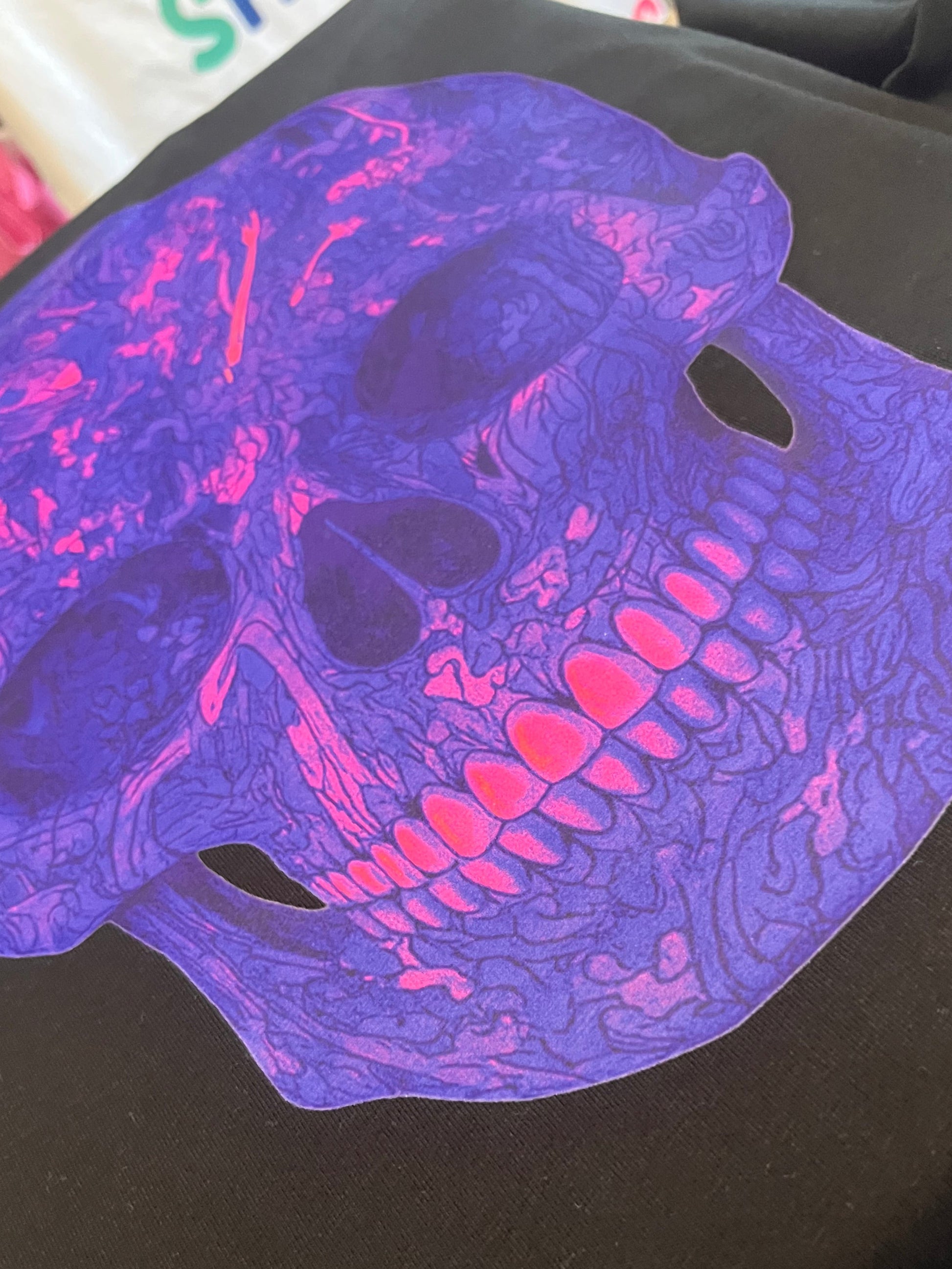 Purple and pink skeleton design on a dark surface