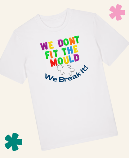 A white short-sleeve t-shirt with a colorful graphic text reading 'WE DONT FIT THE MOULD We Break It!' in rainbow letters, displayed on a light cream background with decorative teal and pink flower graphics. Unite Club x Something Profound