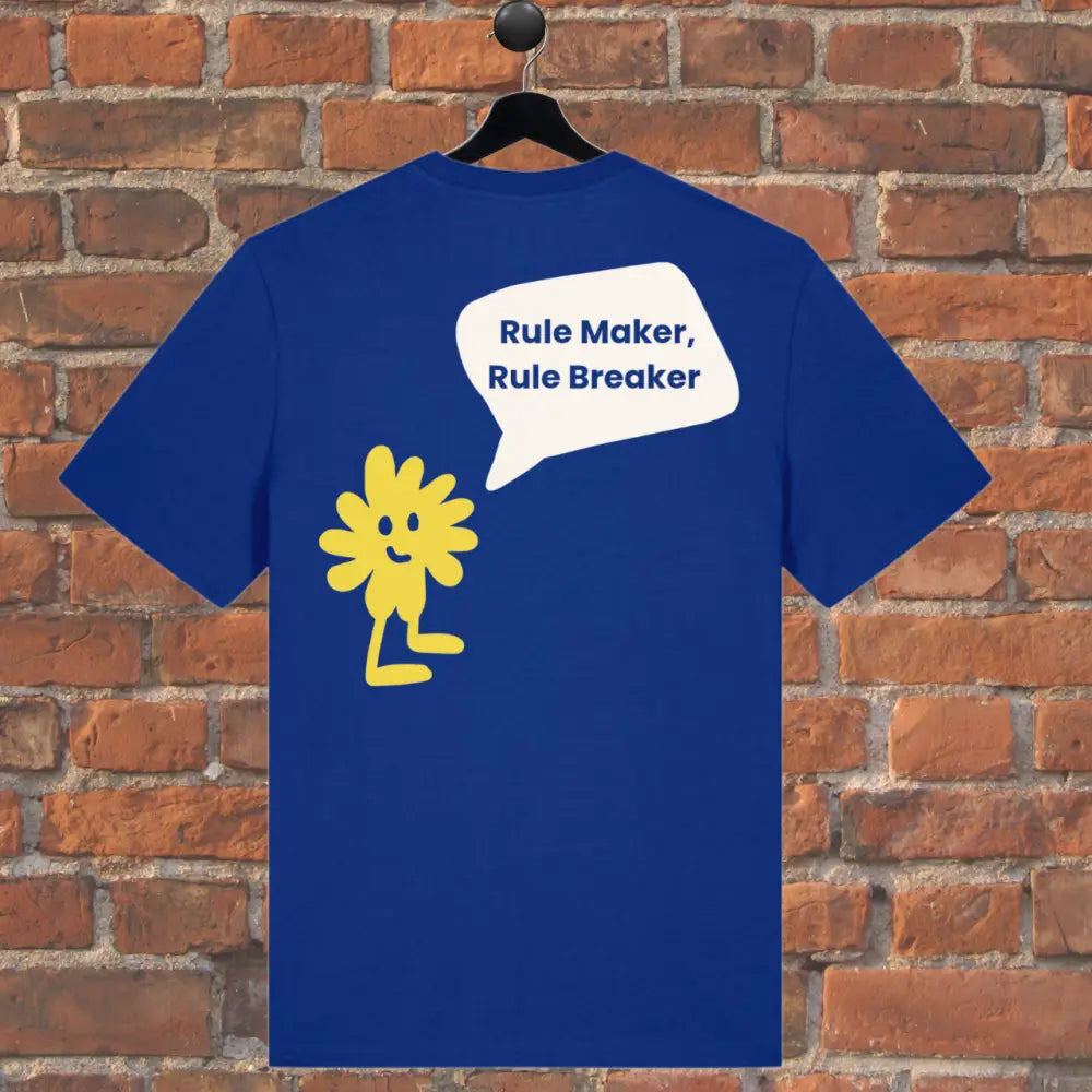 Blue t-shirt with a yellow flower graphic and text 'Rule Maker, Rule Breaker' on a brick wall background