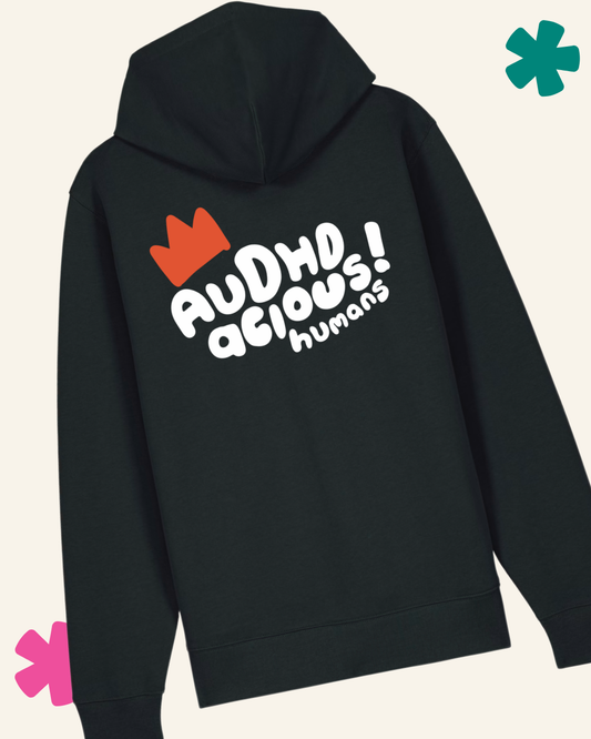Black hoodie with colorful text and graphics on the back against a light beige background