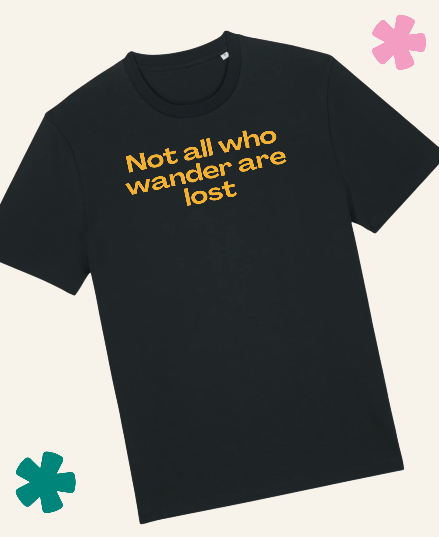 A black short-sleeve crewneck t-shirt with the phrase 'Not all who wander are lost' printed in yellow across the chest, displayed on a light cream background with decorative teal and pink flower graphics in the corners. Unite Club x Something Profound