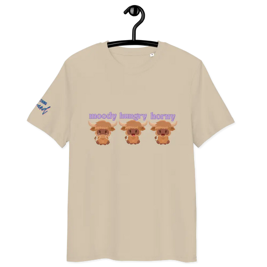Beige t-shirt with cartoon highland cows and text on a hanger against a white background