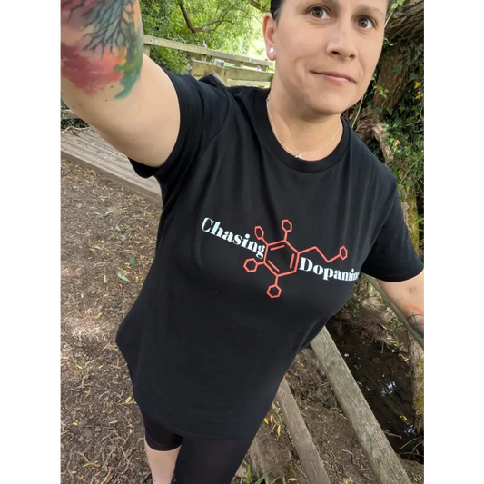 Person wearing a black t-shirt with 'Chasing Dopamine' design outdoors.