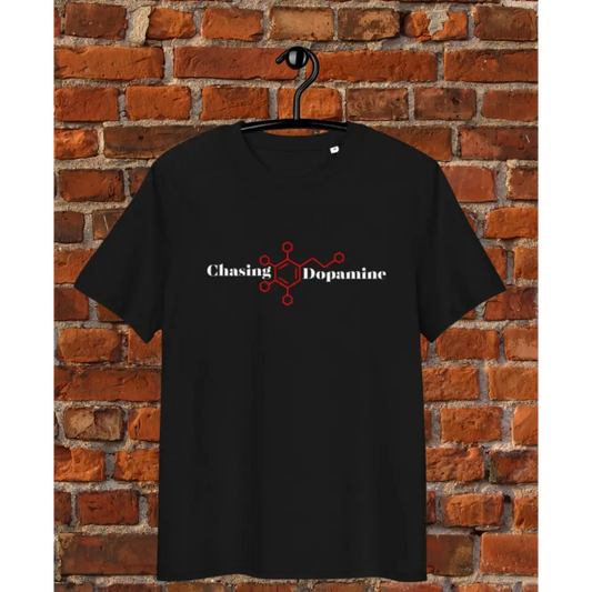 Black t-shirt with 'Chasing Dopamine' design on a hanger against a brick wall background
