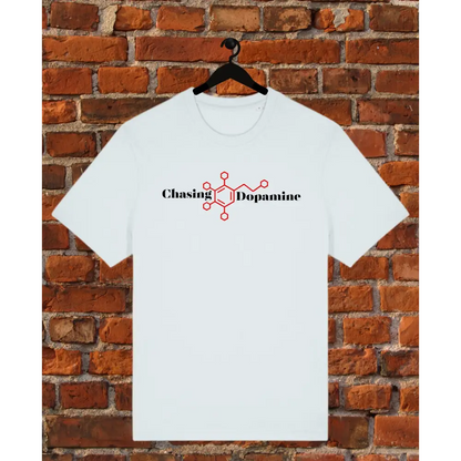 ice blue t-shirt with 'Chasing Dopamine' design on a hanger against a brick wall.
