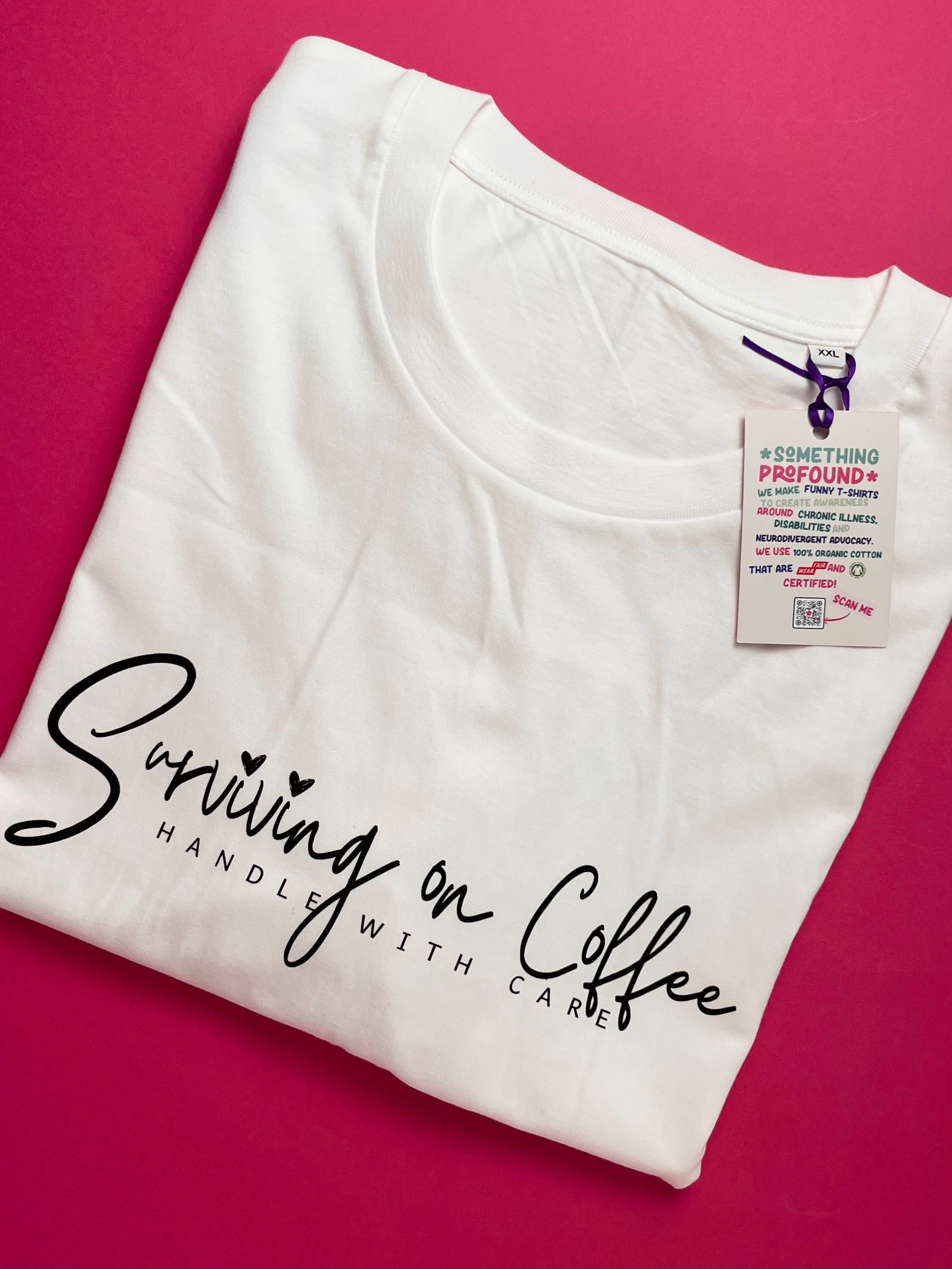 White t-shirt with 'Surviving on Coffee Handle with Care' text on a pink background