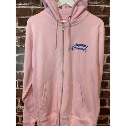 Pink zip hoodie with a logo on a brick wall