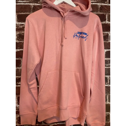 Pink hoodie with blue text on a textured surface