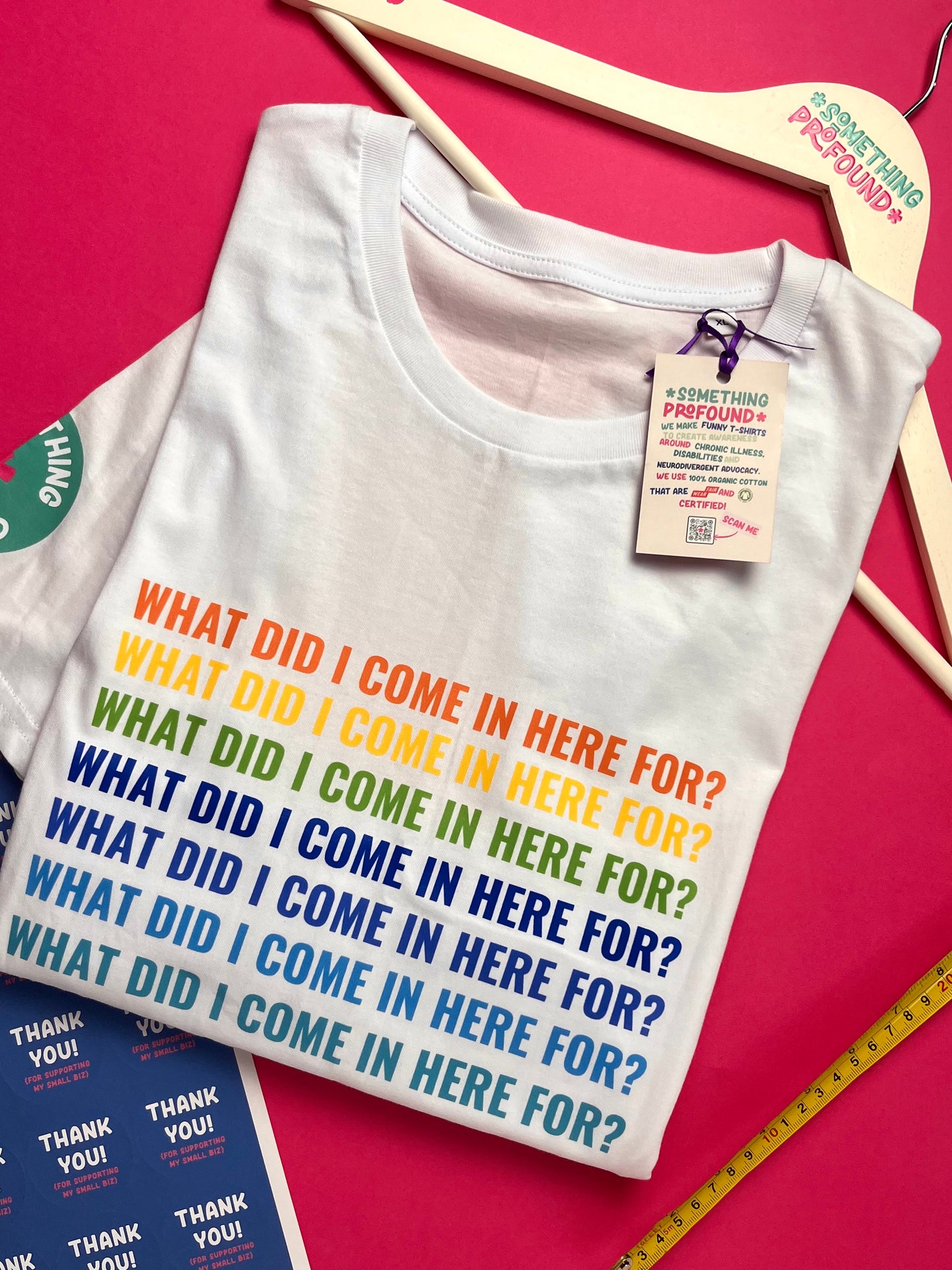 White t-shirt with colorful text on a pink background