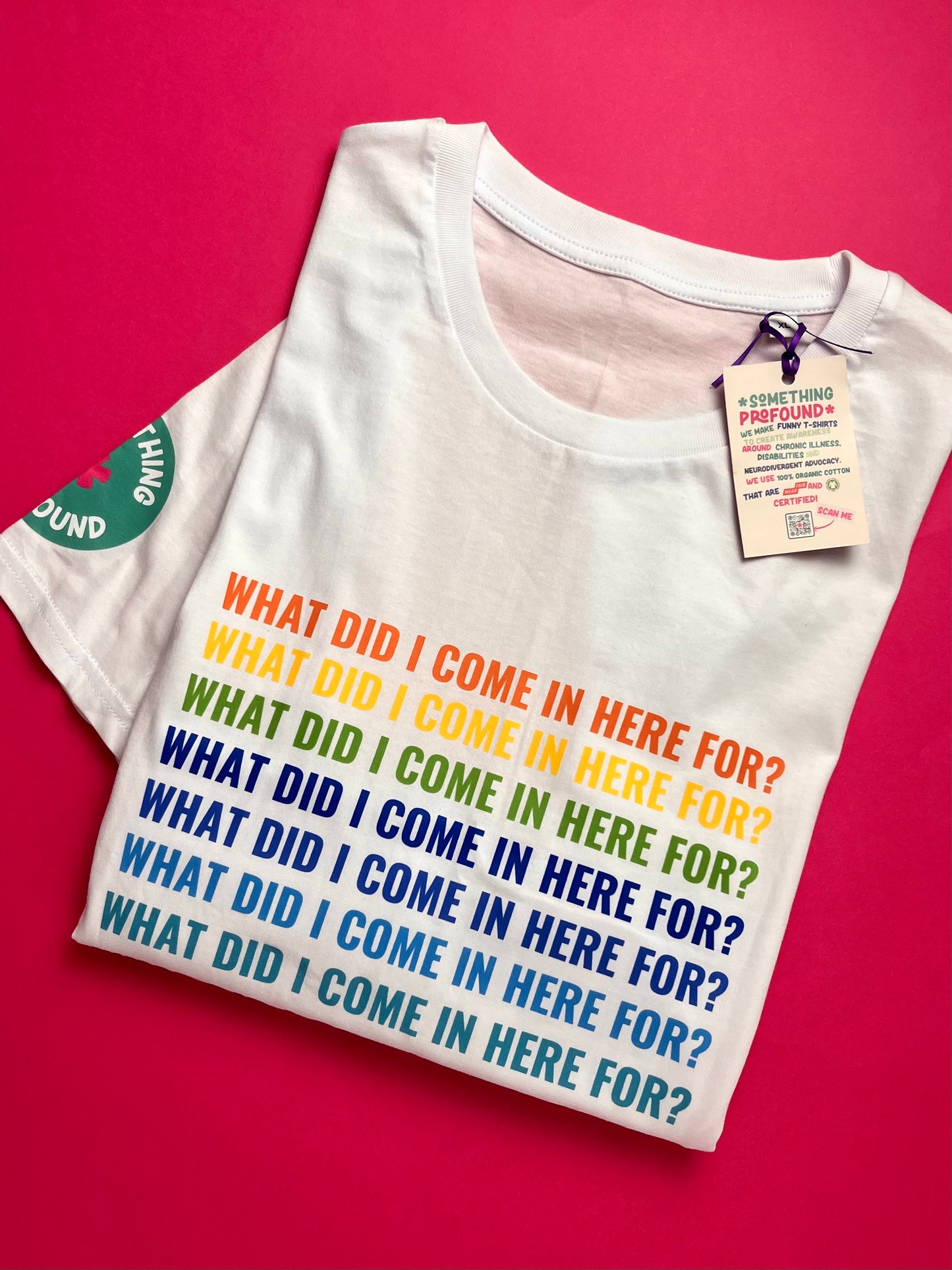 White t-shirt with colorful text on a pink background