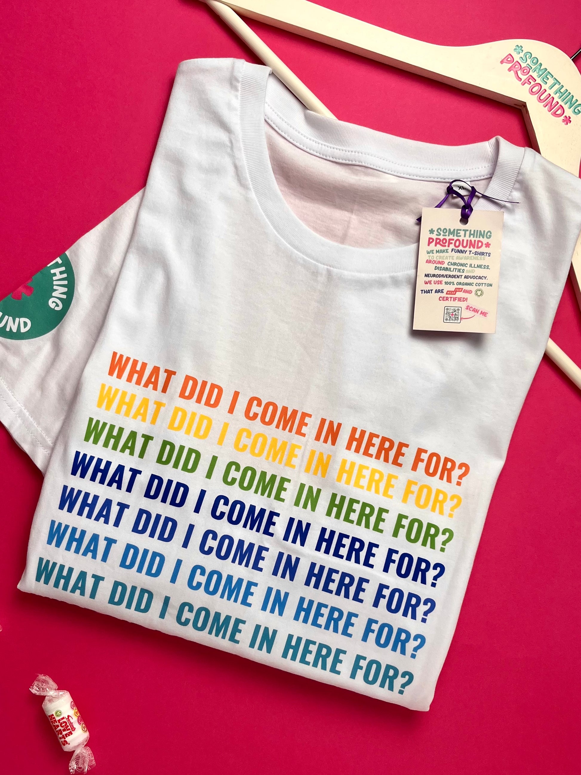 White t-shirt with colorful text on a pink background